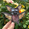 Iridescent purple and orange bat