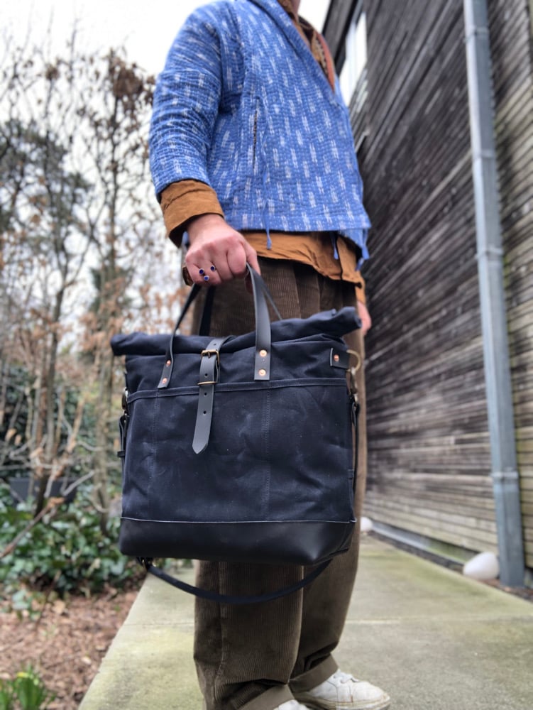 Image of Black waxed canvas carryall with luggage handle attachment leather handles and shoul