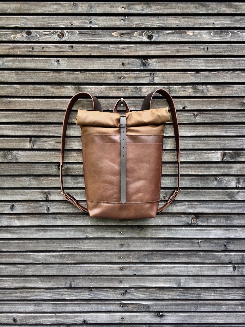 Image of Leather backpack with waxed canvas roll to close top and double outside pocket