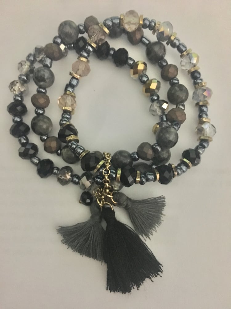 Image of 3 strand bead bracelet with tassel accent.