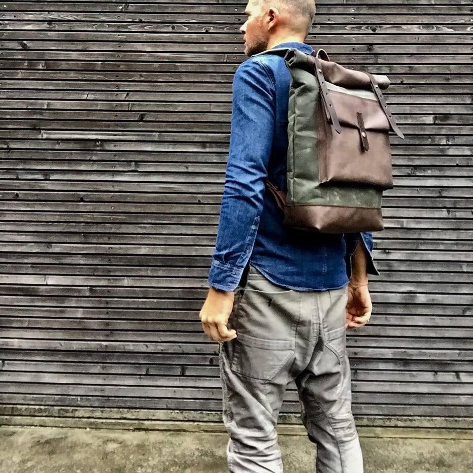 Image of Waxed canvas backpack with roll to close top with leather bottom and outside pocket in dark taupe