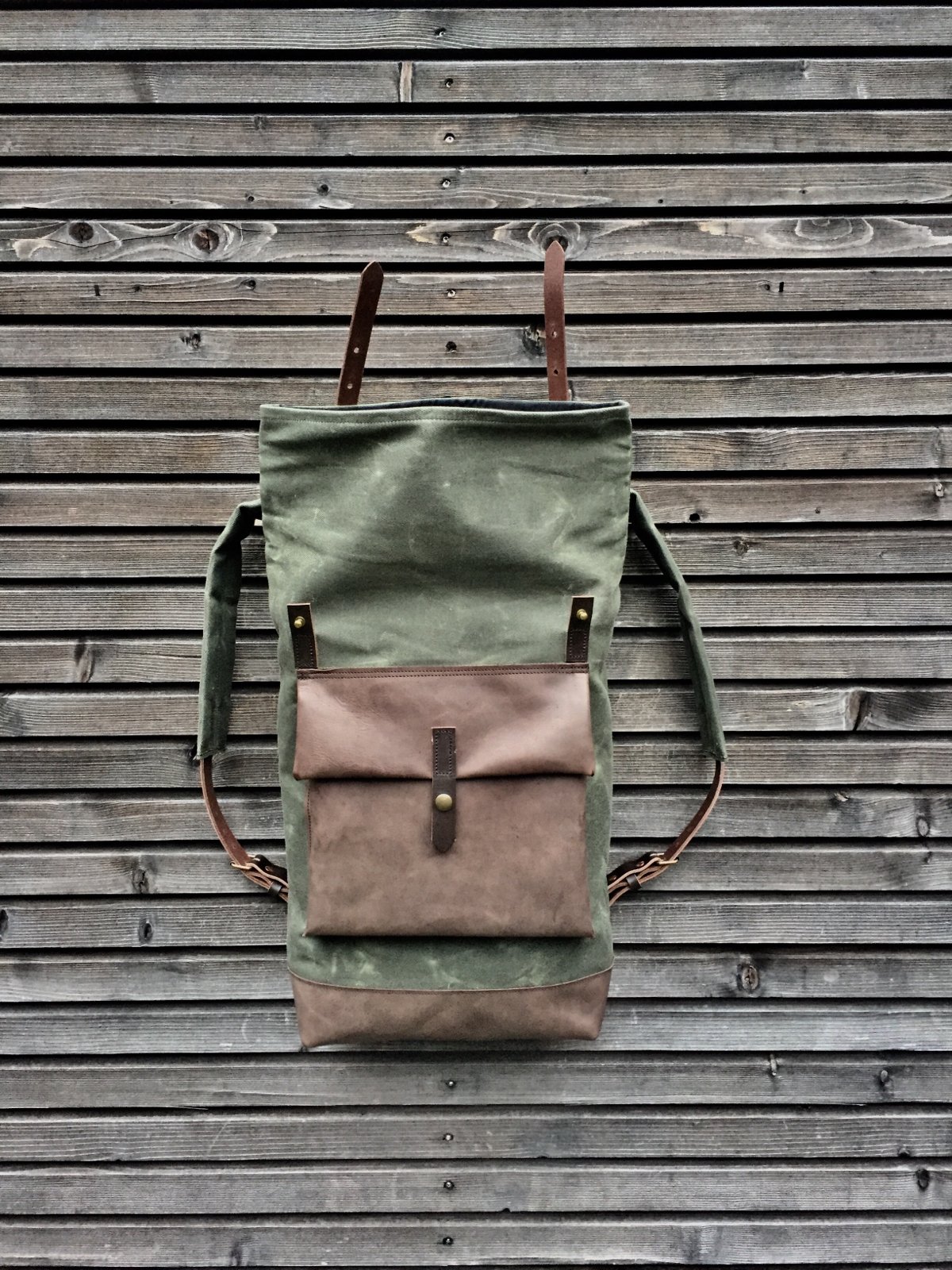 Image of Waxed canvas backpack with roll to close top with leather bottom and outside pocket in dark taupe