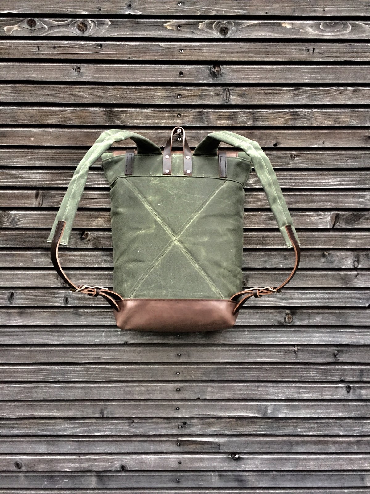 Image of Waxed canvas backpack with roll to close top with leather bottom and outside pocket in dark taupe