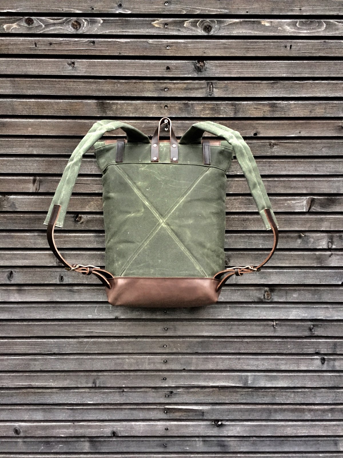 Waxed canvas backpack with roll to close top with leather bottom and  outside pocket in dark taupe