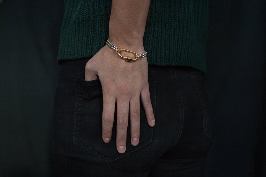 CAUGHT AND BOUND - A PLAY ON INTERLOCKING  -
BOLD AND CHIC IN THE SAME TIME

The 'Bound' bracelet features a flat chunky facetted curbed chain of solid 925 silver.

The modern technical heavy lock which is made of first quality stainless steel, a precious and strong material, which is 32mm long, and 18 karat heavy gold plated. The lock also functions as the connecting part.
