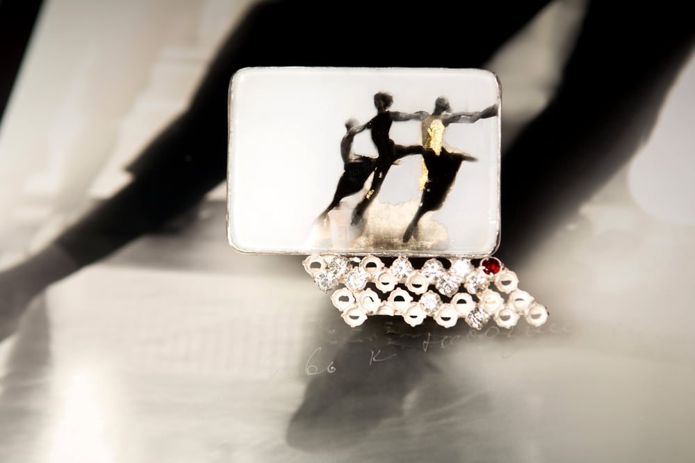 Image of sterling silver brooch with garnet and gold leaf on ballet photography under glass
