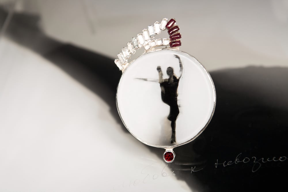 Image of round sterling silver brooch with topaz, garnets and ballet photography under glass