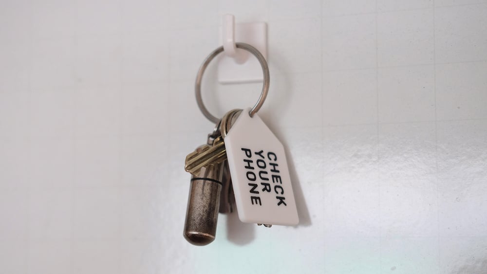 Image of 'Check your phone' - Helpful advice keyring