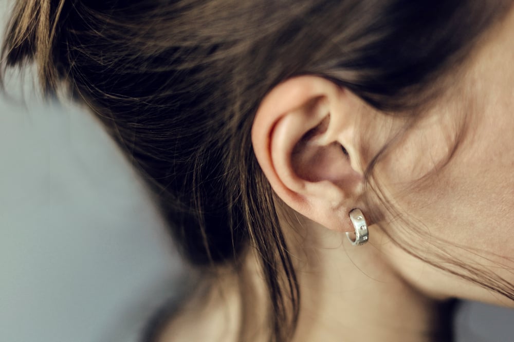 Image of thin round silver earrings with inscription in Latin