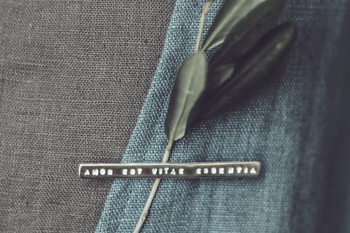 Image of silver brooch with inscription in Latin