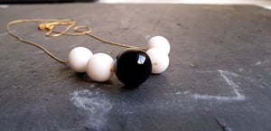 Image of Dominó. Collar largo con encantos en blanco y negro.