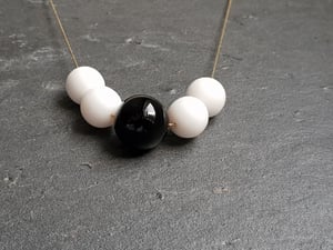 Image of Dominó. Collar largo con encantos en blanco y negro.