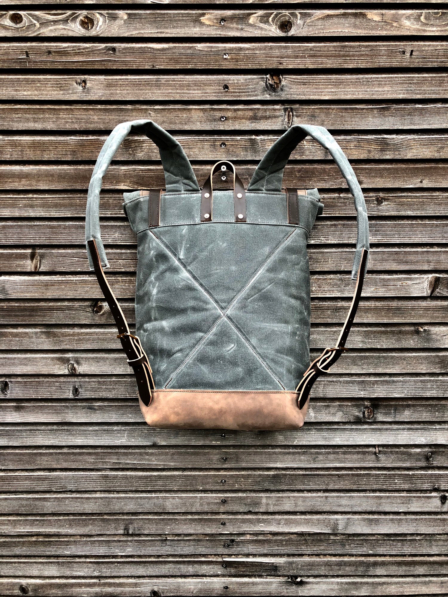 Image of Waxed canvas backpack with roll up top and hand waxed leather bottom and outside pocket