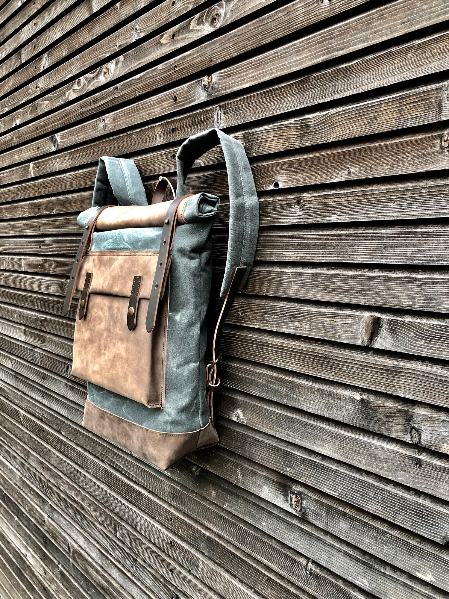 Image of Waxed canvas backpack with roll up top and hand waxed leather bottom and outside pocket
