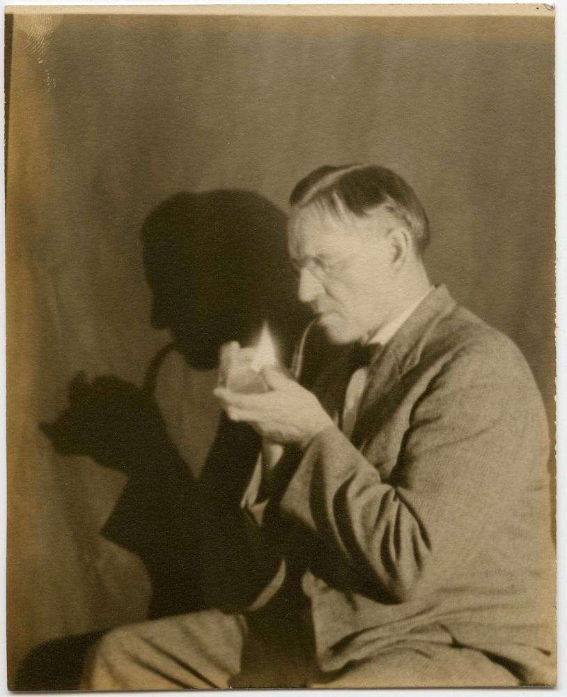 Image of Anonymous: man lighting his pipe with fascinating shadow, ca. 1935