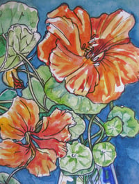 Image 2 of Orange Nastursiums in a blue glass vase