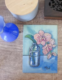 Image 3 of Pink orchids in a glass jar by candle light
