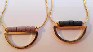 Image of Lucía. Collar corto con media luna dorada y abalorios de cristal.