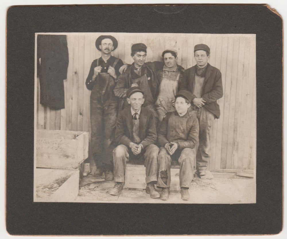 Image of Six workers posing with their denim overall, ca. 1903