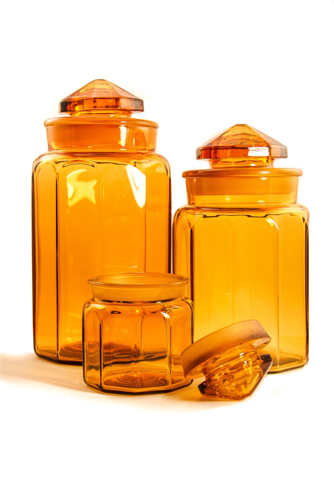 Three Covered Amber Canisters