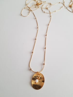 Image of Olivia. Collar muy largo con cadena fina, detalle de medalla dorada y cuenta de cristal de Swarovski
