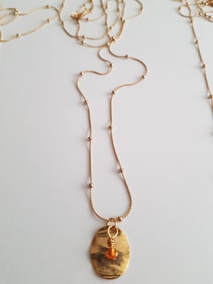 Image of Olivia. Collar muy largo con cadena fina, detalle de medalla dorada y cuenta de cristal de Swarovski