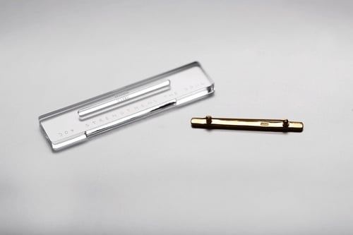 Image of gold plated silver brooch with inscription in Latin