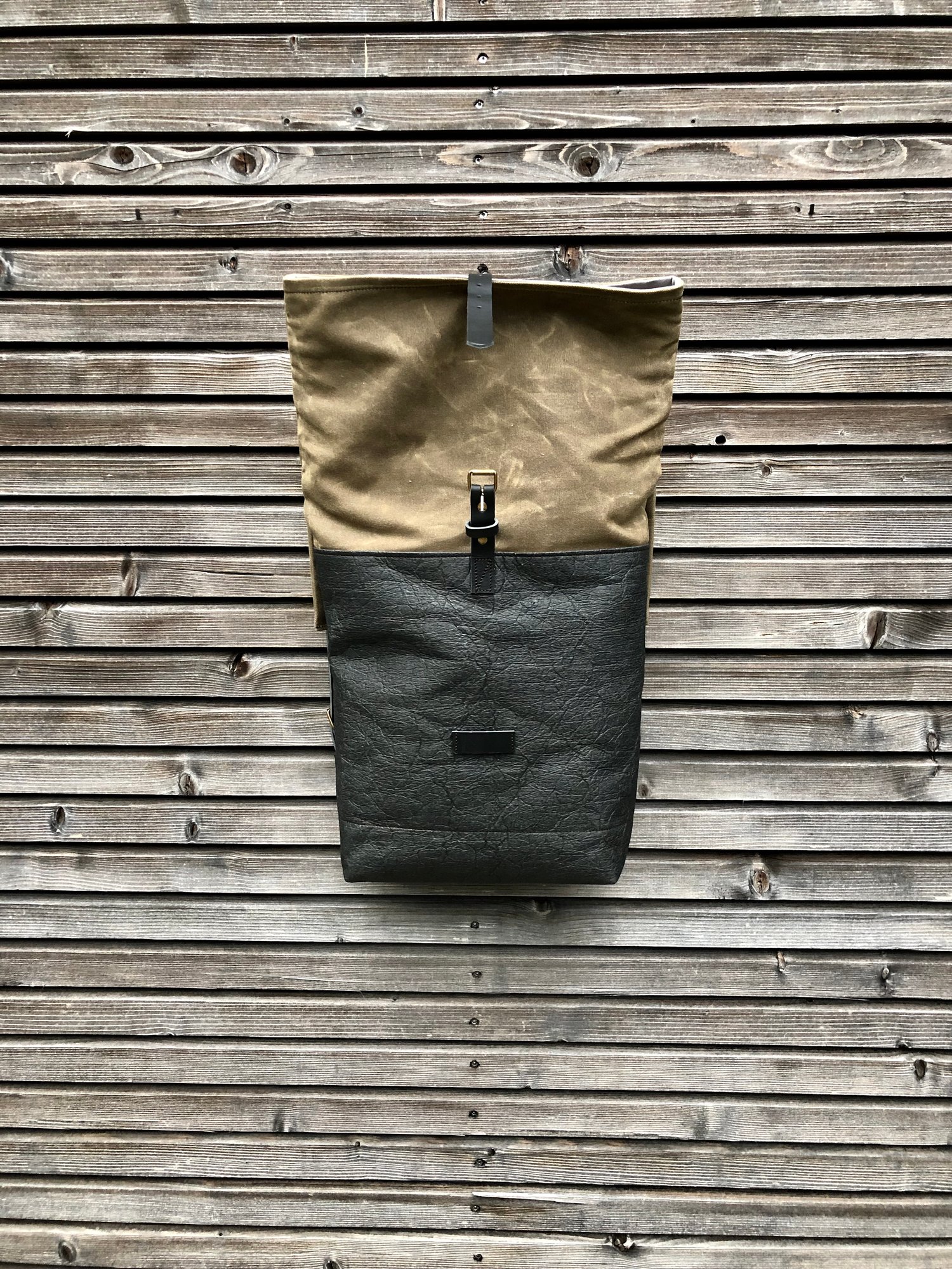 Image of Vegan backpack in black Piñatex™ and field tan waxed canvas with roll to close top
