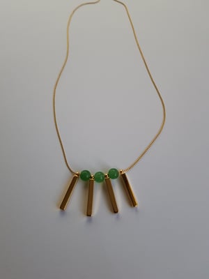 Image of Valentina (mediano). Collar largo con detalle de piedra semipreciosa y charms en dorado.