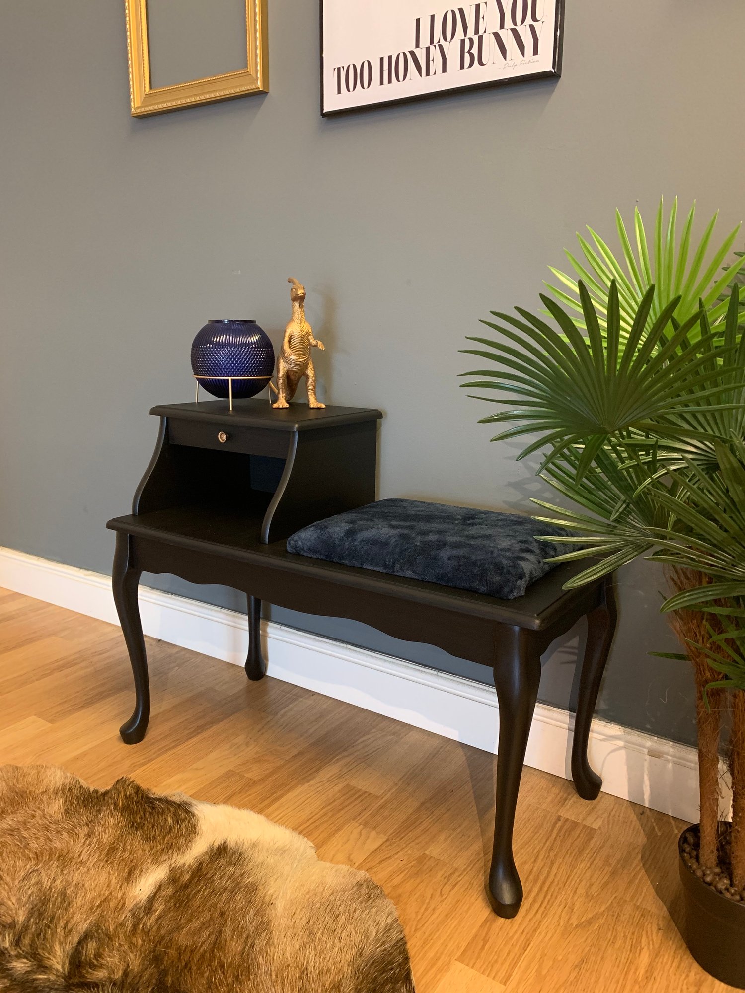 Image of A black telephone table with a navy blue fluffy seat.