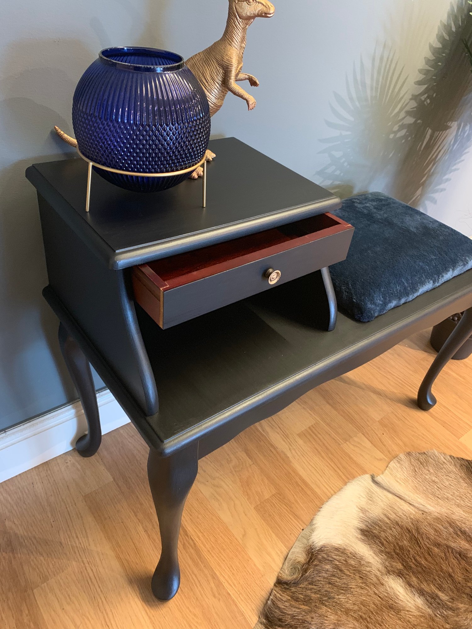 Image of A black telephone table with a navy blue fluffy seat.