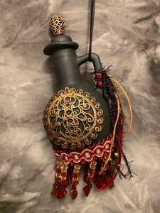 Image of Maroon ,black and copper bottle with fringe and copper accents.