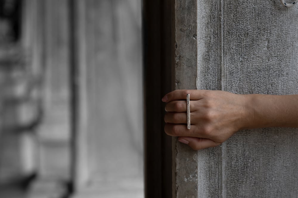 Image of silver plain ring with inscription · BEAUTY IS THE ETERNAL PRESENT ·
