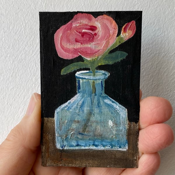 Image of pink rose in an antique perfume bottle