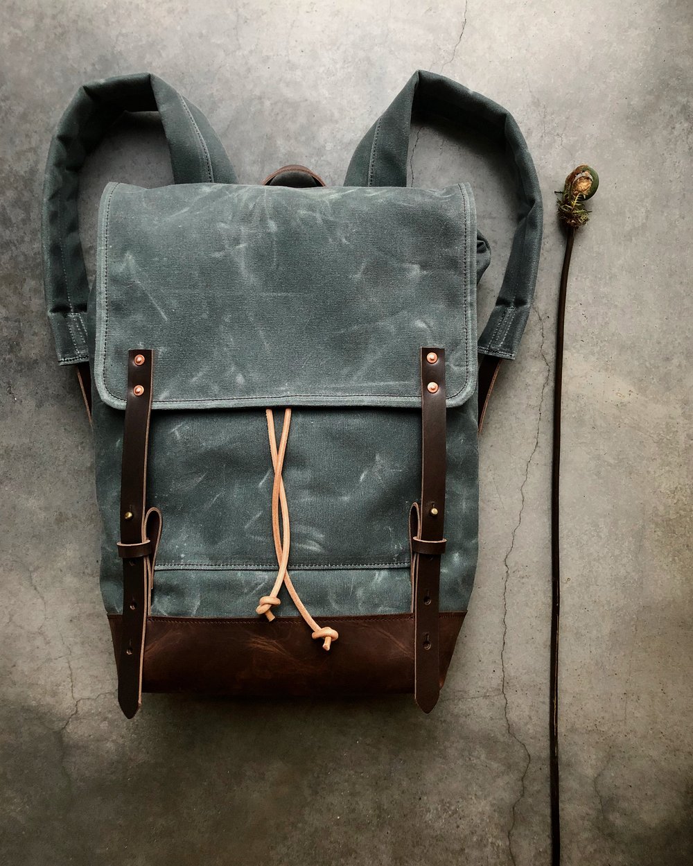 Backpack in gray waxed canvas rucksack with folded top and waxed canvas flap