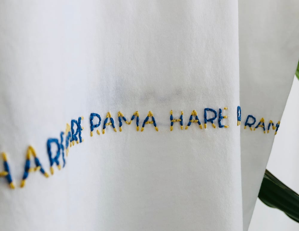 Image of MAHA MANTRA – wrapped – blue/yellow – white t-shirt w/ rolled-up sleeves