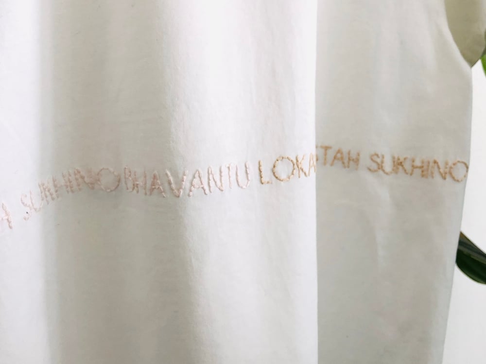 Image of LOKAH SAMASTAH SUKHINO BHAVANTU – wrapped – light blue/beige/rose – white unisex t-shirt