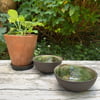 Small black clay bowl, white slip & green glaze interior