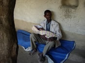 Image of Farmer cradling his baby by Alem Assefa (print)