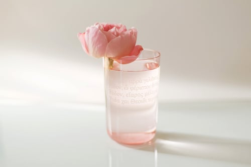 Image of VERBA pink water glass with inscription in Latin or Ancient Greek