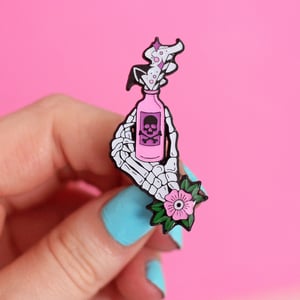 Image of Skeleton hand holding poison bottle - anatomy - creepy cute - pastel goth - spooky - lapel pin badge