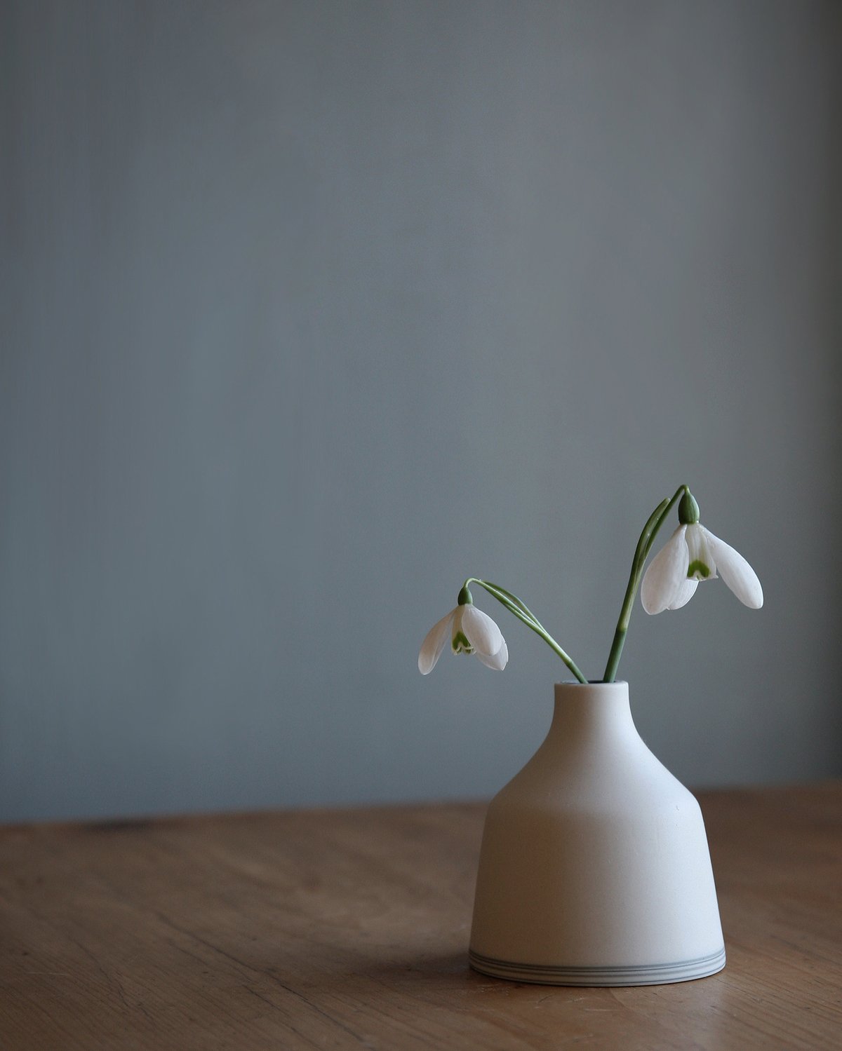 Image of Small white bud vase, with layered base. 