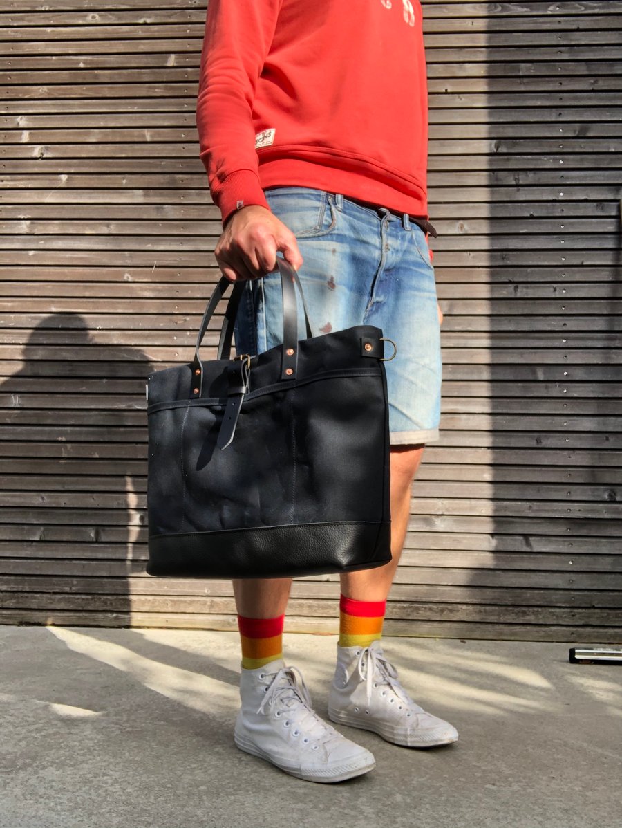 Image of Black tote bag in waxed canvas with leather bottom and cross body strap