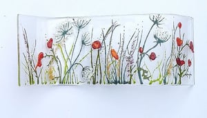 Lying in a field surrounded by swaying wildflowers