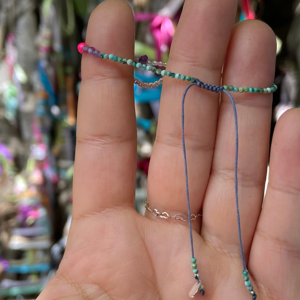 Image of tiny stones and charm bracelet