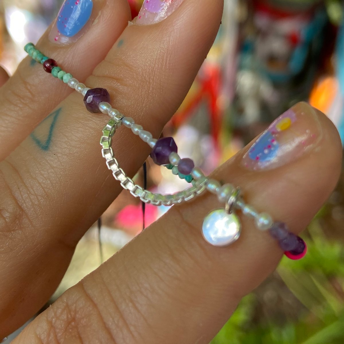 Image of tiny stones and charm bracelet
