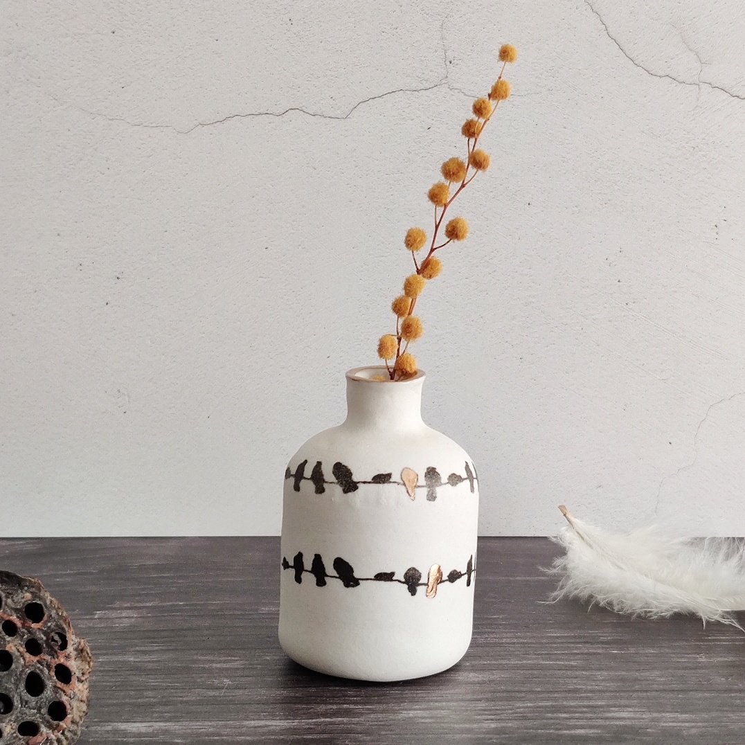 Porcelain birds on a wire bottle