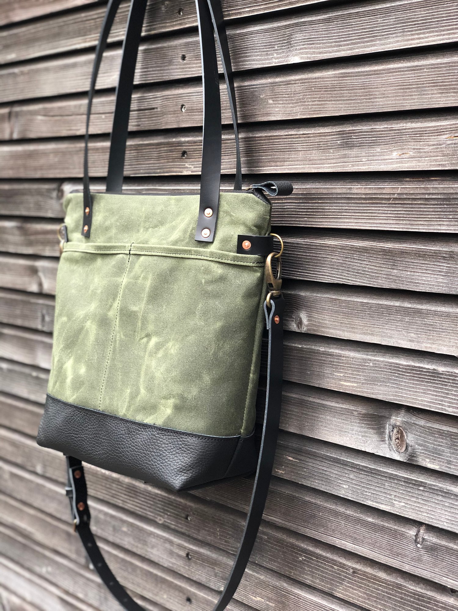 Image of Waxed canvas leather tote bag in olive green with zipper closure and cross body strap