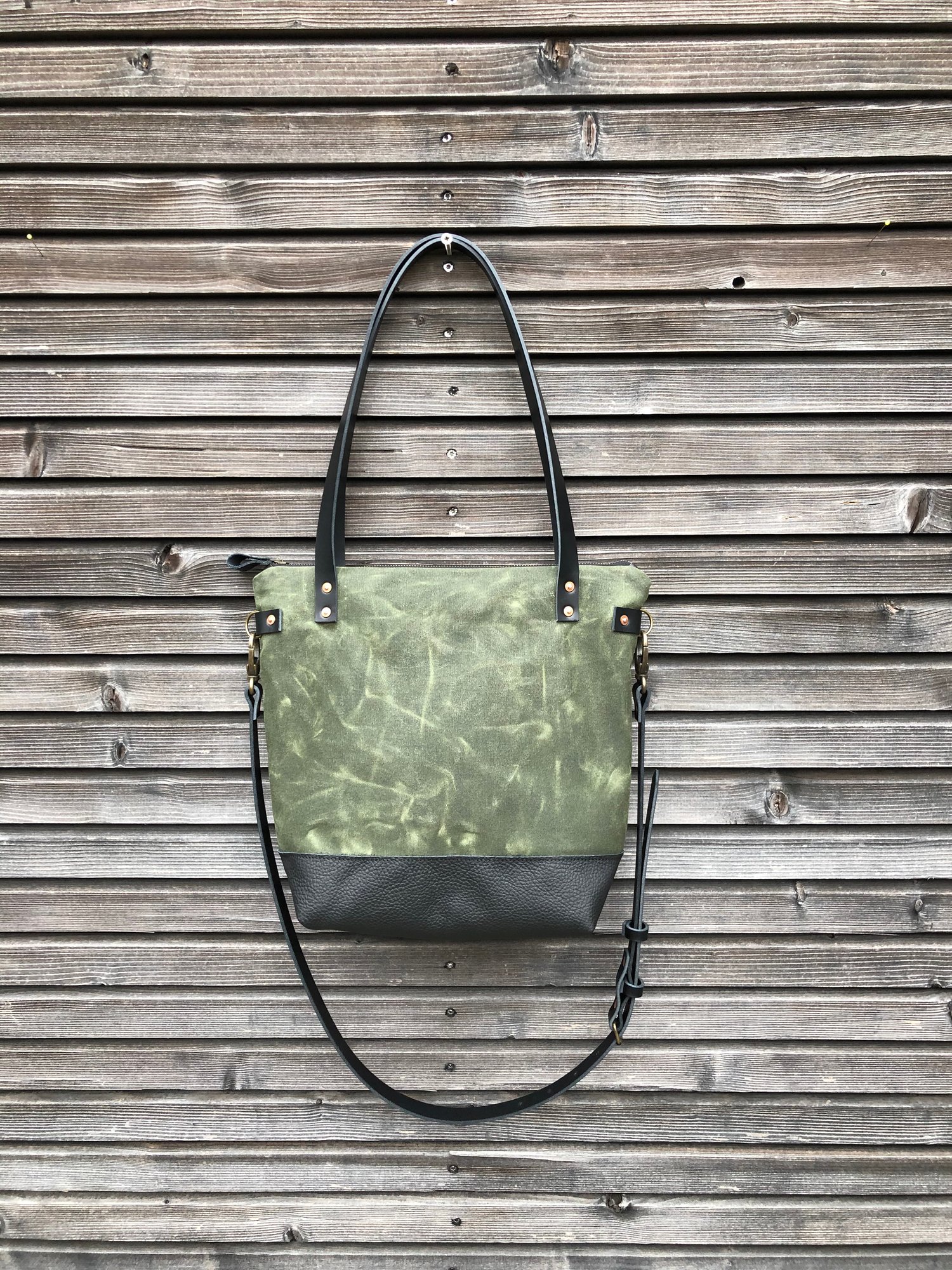 Image of Waxed canvas leather tote bag in olive green with zipper closure and cross body strap