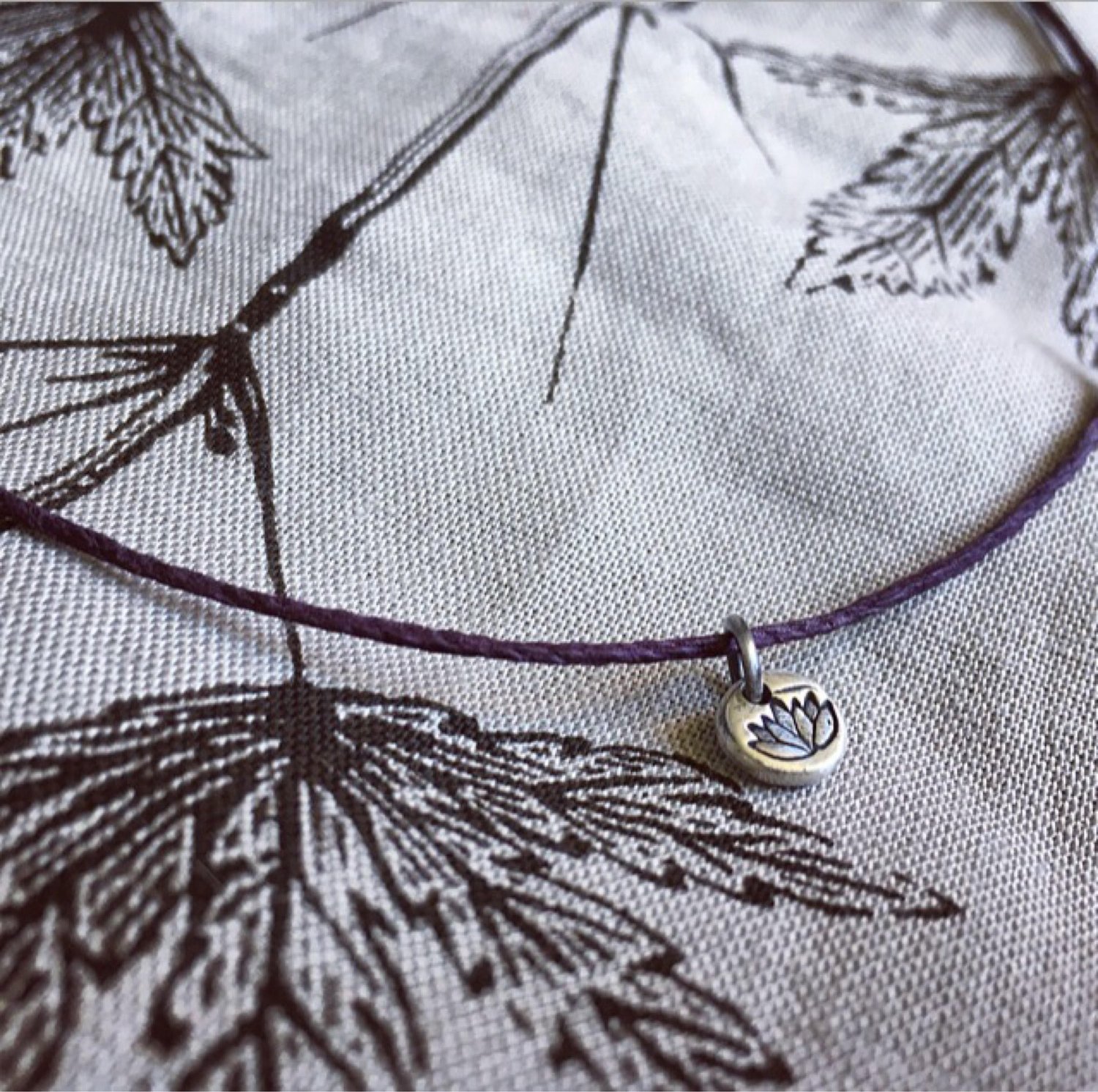 Image of Lotus flower charm necklace. Handmade silver charm, waxed hemp cord adjustable necklace